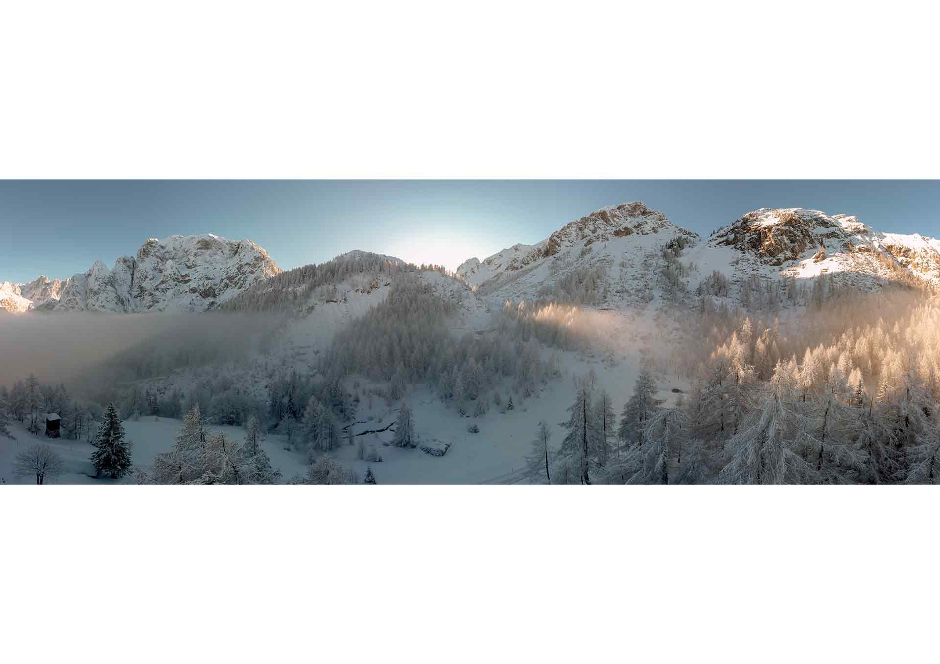 Winter sun flares through the fog on Vršič pass.